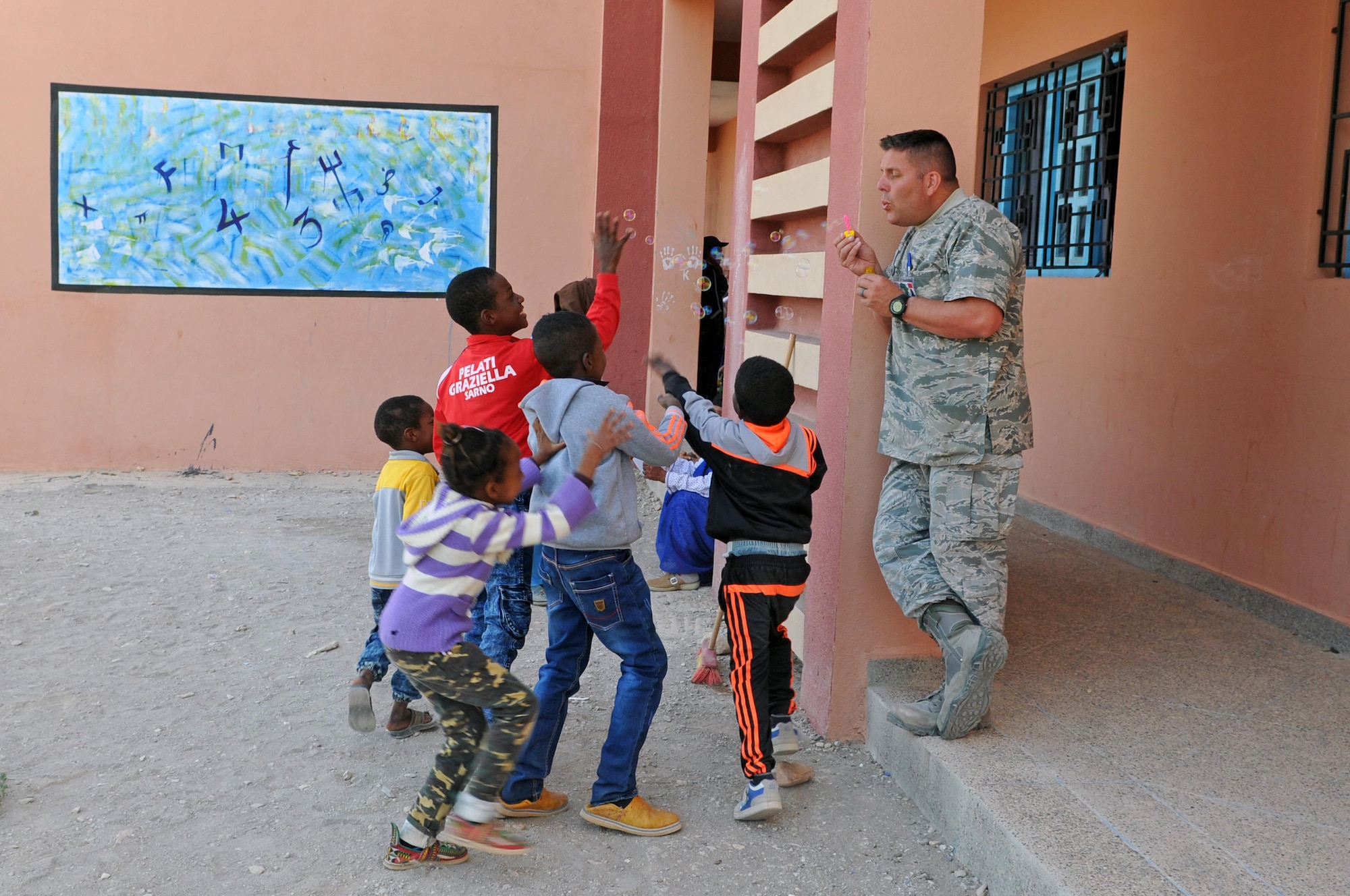 Staff Sgt. Erik Bornemeier, a medical technician with the 151st Medical Group, entertains a group of children waiting outside of the clinic in Issafen, Morocco on April 25, 2017 during African Lion. (U.S. Air National Guard photo by Tech. Sgt. Annie Edwards)