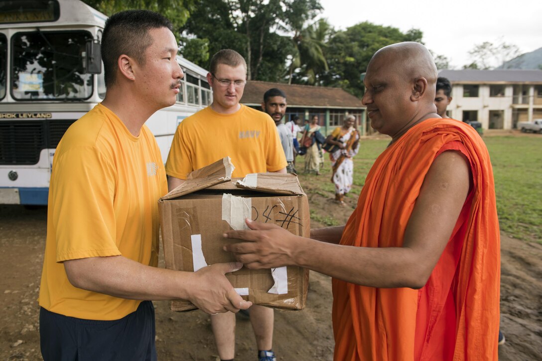 Navy Lt. Matthew Fore, who's assigned to the Ticonderoga-class guided-missile cruiser USS Lake Erie, delivers sanitation packs to the principal of the Mallika Nawodya School in Sri Lanka during a community engagement event in support of humanitarian assistance operations in the wake of severe flooding and landslides that devastated many regions of the country near Galle, Sri Lanka, June 14, 2017. Recent heavy rainfall brought by a southwestern monsoon triggered flooding and landslides throughout the country, displacing thousands of people and causing significant damage to homes and buildings. Navy photo by Petty Officer 2nd Class Joshua Fulton