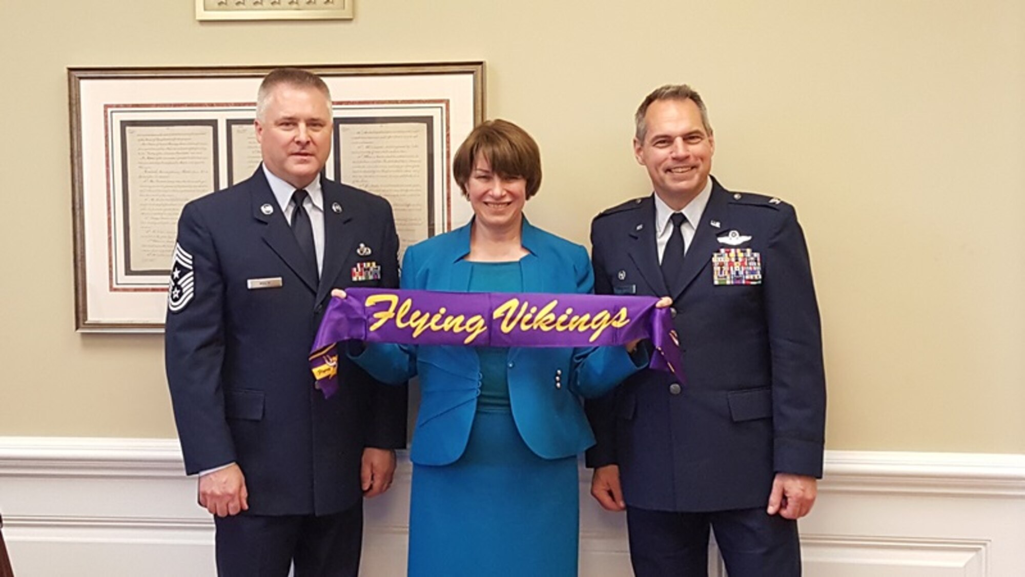 Senator Amy Klobuchar displays the Flying Vikings scarf with Col. Tony Polashek, 934th Airlift Wing commander (right) and Chief Master Sgt. Anthony Mack, 934th Airlift Wing command chief, during their visit to her Washington D.C. office June 7. During the visit they discussed issues important to the Airmen of the 934th Airlift wing and Air force Reserve.