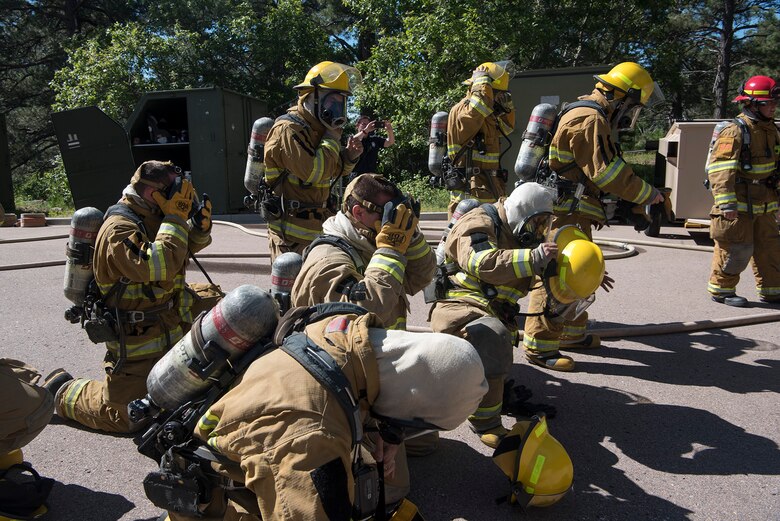 CHEYENNE MOUNTAIN AIR FORCE STATION, Colo. – Recruits from the Colorado Springs Fire Department training division don personal protective gear before entering the flashover trainer at Cheyenne Mountain Air Force Station, Colo., fire training area, June, 9, 2017. The Colorado Springs Fire Department is able to use the Cheyenne Mountain AFS fire training area as part of a mutual agreement of support between the departments. (U.S. Air Force photo by Steve Kotecki)