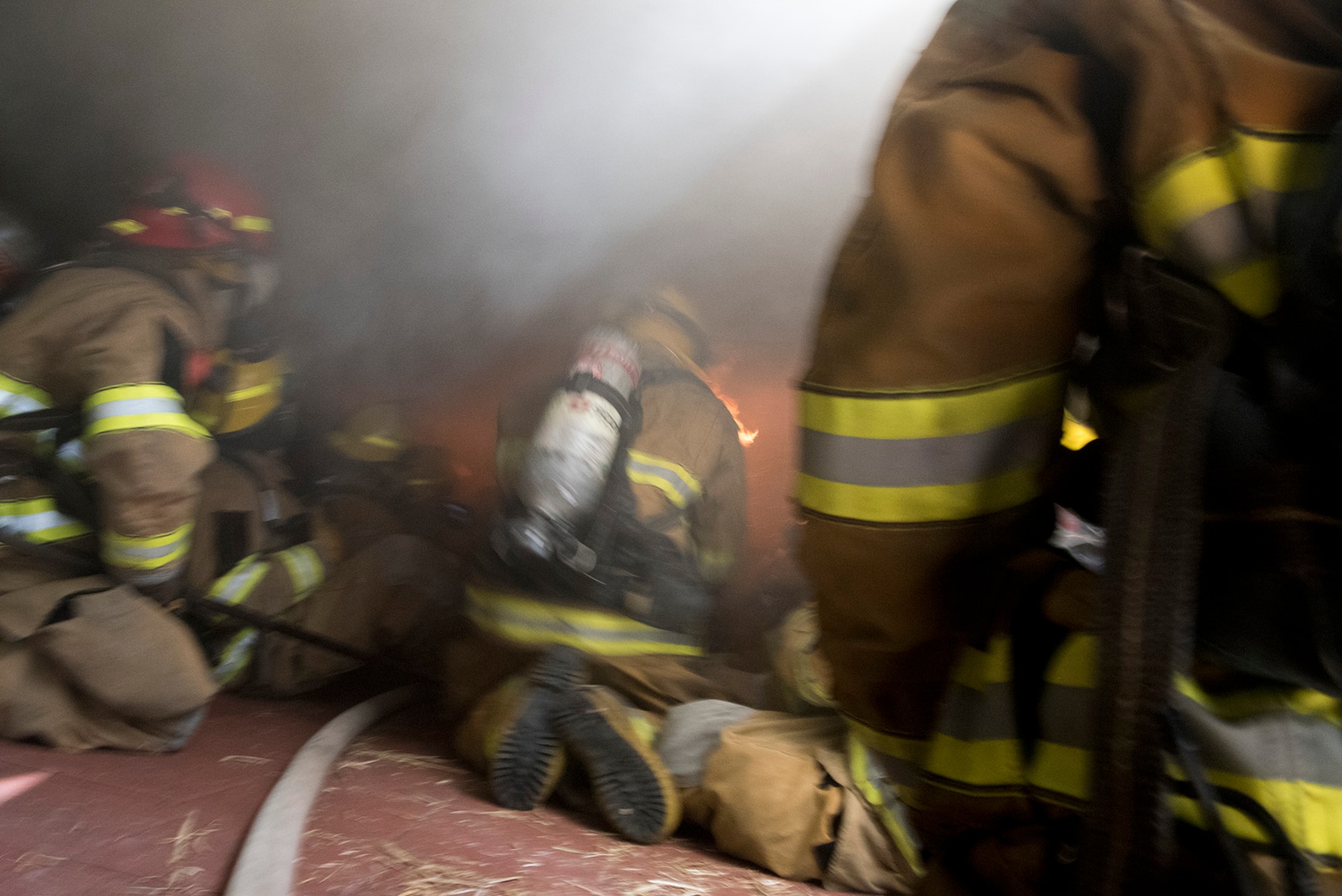 CHEYENNE MOUNTAIN AIR FORCE STATION, Colo. – Instructors from the Colorado Springs Fire Department training division add more fuel to the fire during flashover training at the Cheyenne Mountain Air Force Station, Colo., fire training area, June, 9, 2017. The fire is set inside the flashover trainer and controlled by limiting the amount of oxygen that can reach it until the flashover effect is needed. (U.S. Air Force photo by Steve Kotecki)