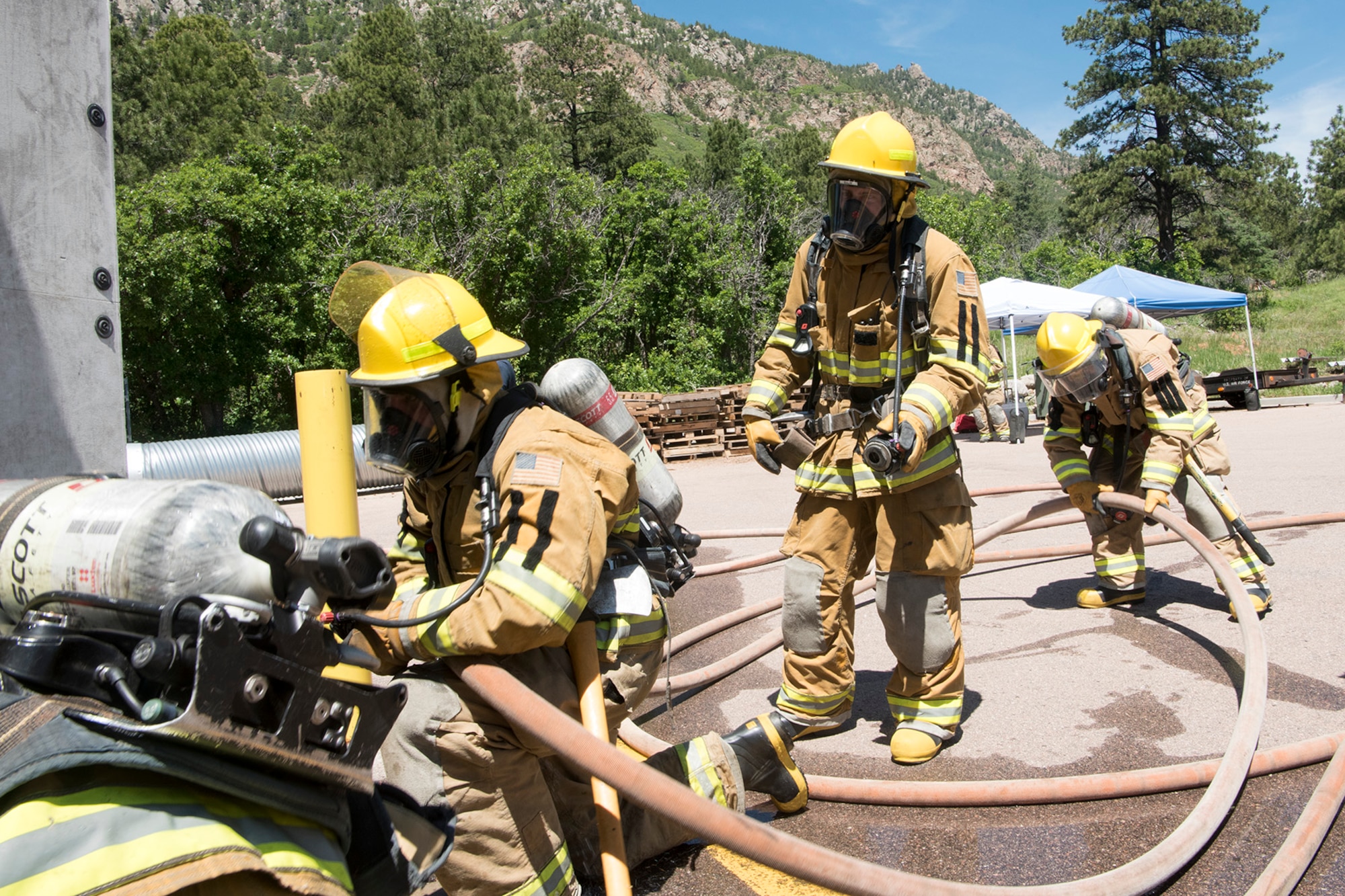 CHEYENNE MOUNTAIN AIR FORCE STATION, Colo. – Recruits from the Colorado Springs Fire Department training division set up firefighting hose while training at the Cheyenne Mountain Air Force Station, Colo., fire training area, June, 9, 2017. The training is designed to get the recruits to think as a team while under the stressful conditions of a controlled fire. (U.S. Air Force photo by Steve Kotecki)
