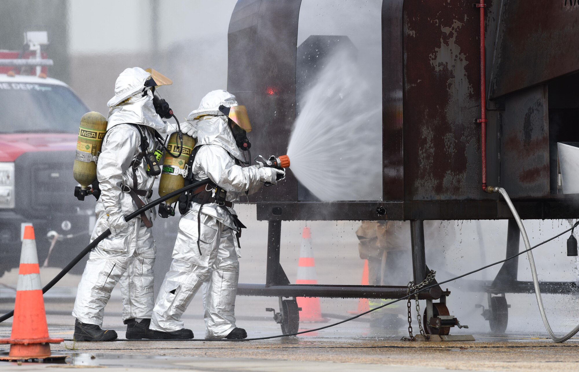 Staff Sgt. Logan Knutson and Airman 1st Class Hannah Reichert, 81st Infrastructure Division firefighters, use a hand-held hose to extinguish a firefighter training aid during live fire exercise on the flightline June 7, 2017, on Keesler Air Force Base, Miss. The Keesler Fire Department, the Gulfport CRTC Fire Department and the Stennis Space Center Fire Department are all required to practice Aircraft Rescue and Fire Fighting procedures to meet a semi-annual training requirement. (U.S. Air Force photo by Kemberly Groue)