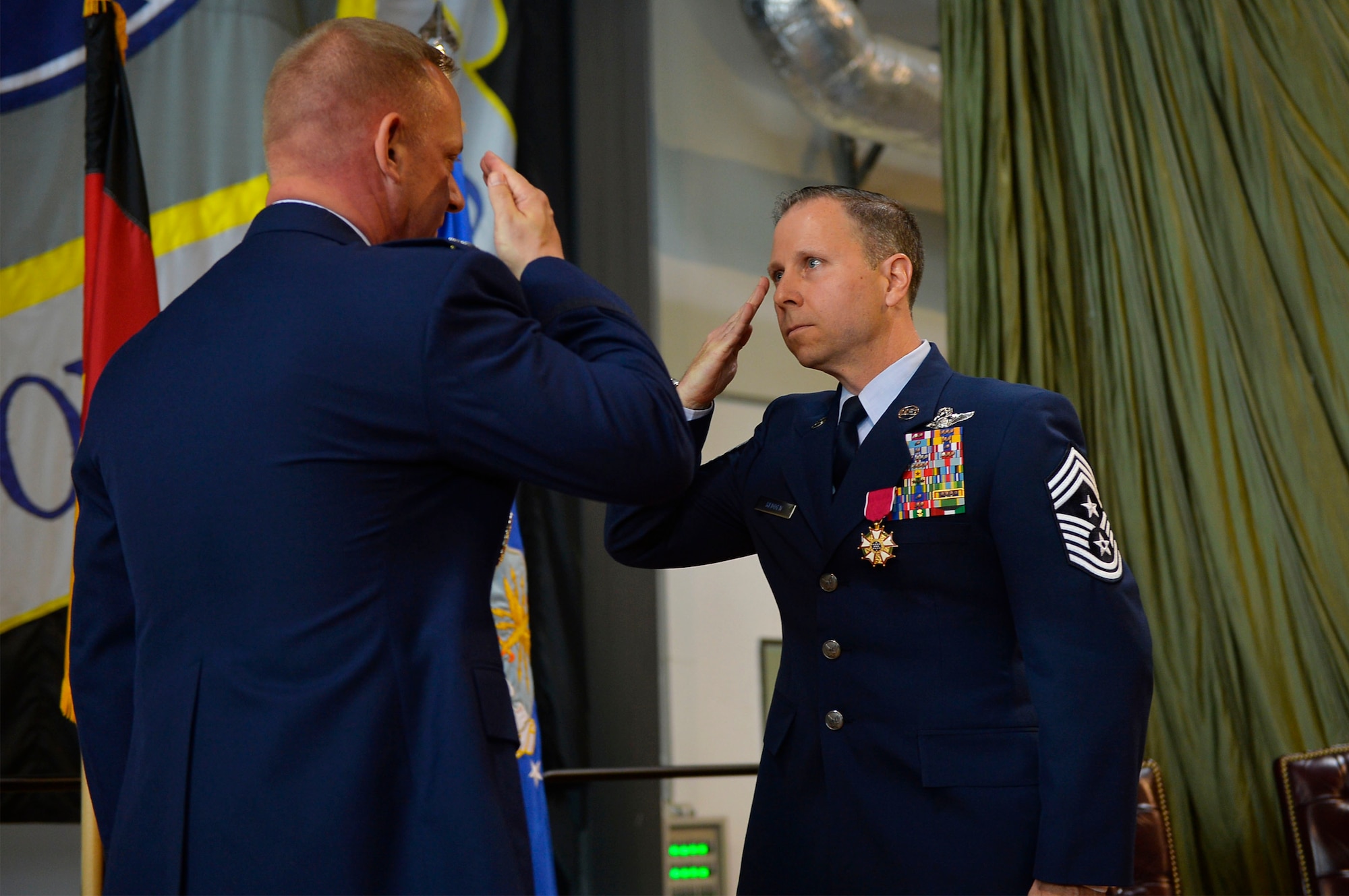 Retiring command Chief Master Sgt. Mark Redden salutes Col. Thomas A. Cooper, 521st Air Mobility Operations Wing commander, during his retirement ceremony recently.