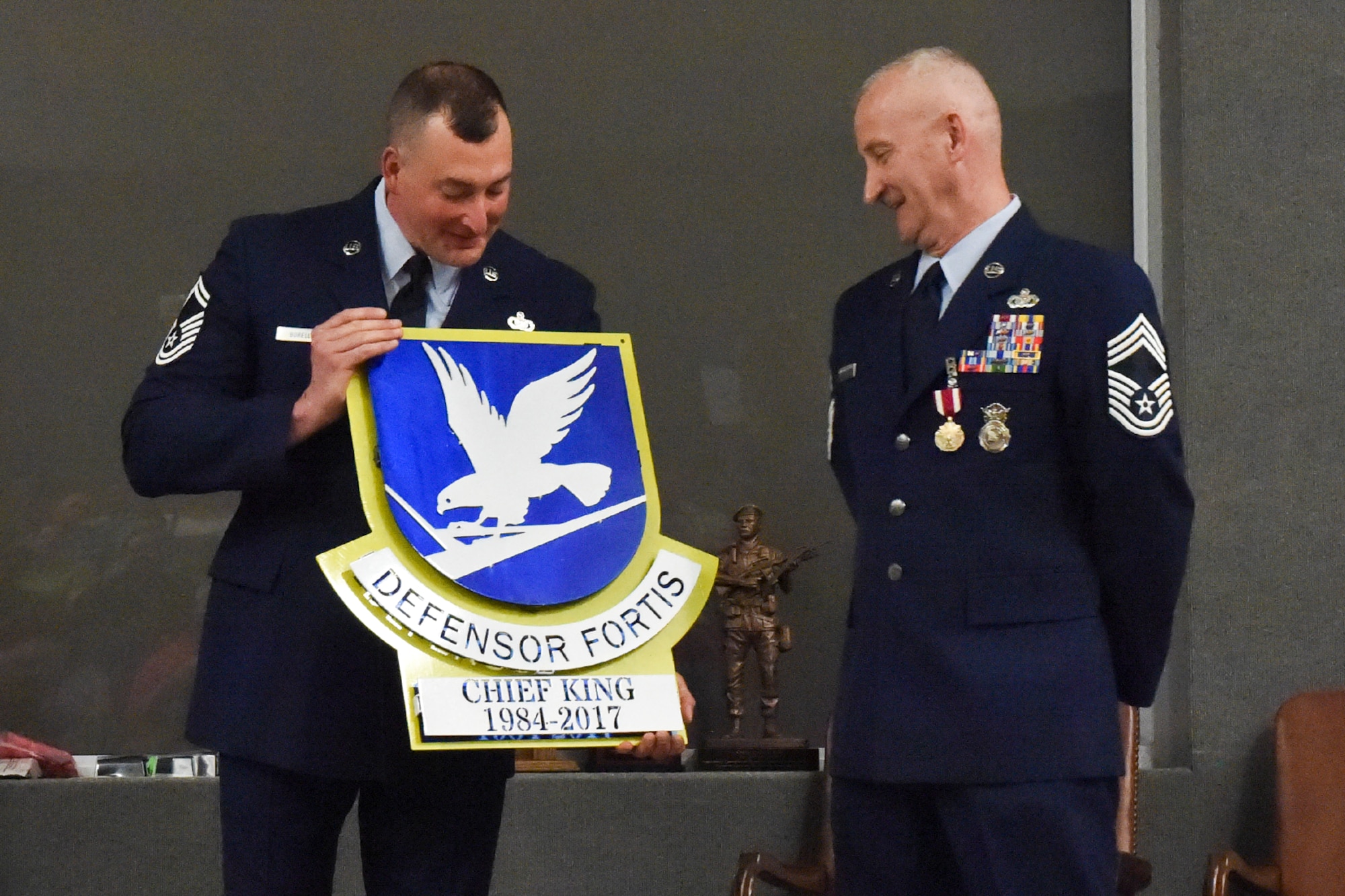 Senior Master Sgt. Stephen Borello, 434th Security Forces Squadron superintendent presents a Defensor Fortis sign to Chief Master Sgt. Rickie King, 434th SFS manager at a retirement ceremony at Grissom Air Reserve Base, Ind., June 3, 2017. This sign signifies King’s entire career serving as a security forces defender. (U.S. Air Force photo/ Senior Airman Cali Wetli)