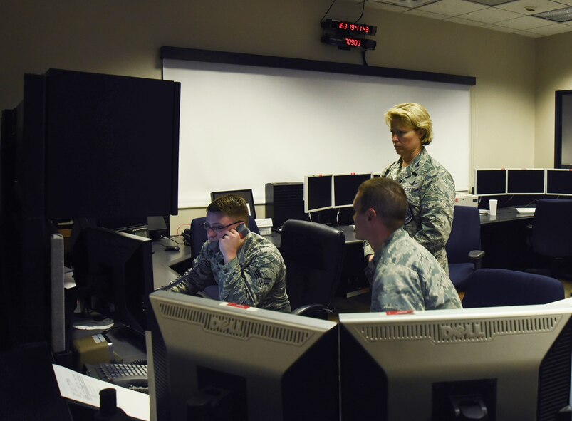 Col. DeAnna Burt, 50th Space Wing Commander, prepares to give the final command to decommission satellite 32 to Senior Airman Brandon Myers, 2nd Space Operations Squadron satellite system operator, at Schriever Air Force Base, Colorado, Monday, June 12, 2017. The disposal process began on June 5 with the spin-stabilized configuration. (U.S. Air Force photo/Airman 1st Class William Tracy)