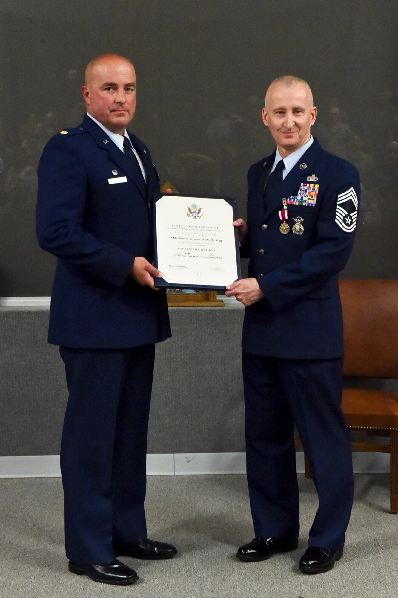 Maj. Matthew Garvelink, 434th Security Forces Squadron commander, presents a certificate of retirement to Chief Master Sgt. Rickie King, 434th SFS manager, at a retirement ceremony at Grissom Air Reserve Base, Ind., June 3, 2017. King retired after serving 27 years in the Air Force. (U.S. Air Force photo/ Senior Airman Cali Wetli)