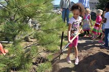 Nylah Council throws dirt at the base of a newly planted tree during the Arbor Day celebration at the Child Development Center at Schriever Air Force Base, Colorado, Friday, June 9, 2017.  Arbor Day promotes tree planting and conservation.  This year, Schriever was recognized for its 19th consecutive year as a Tree City USA recipient. (U.S. Air Force Photo/Dennis Rogers)