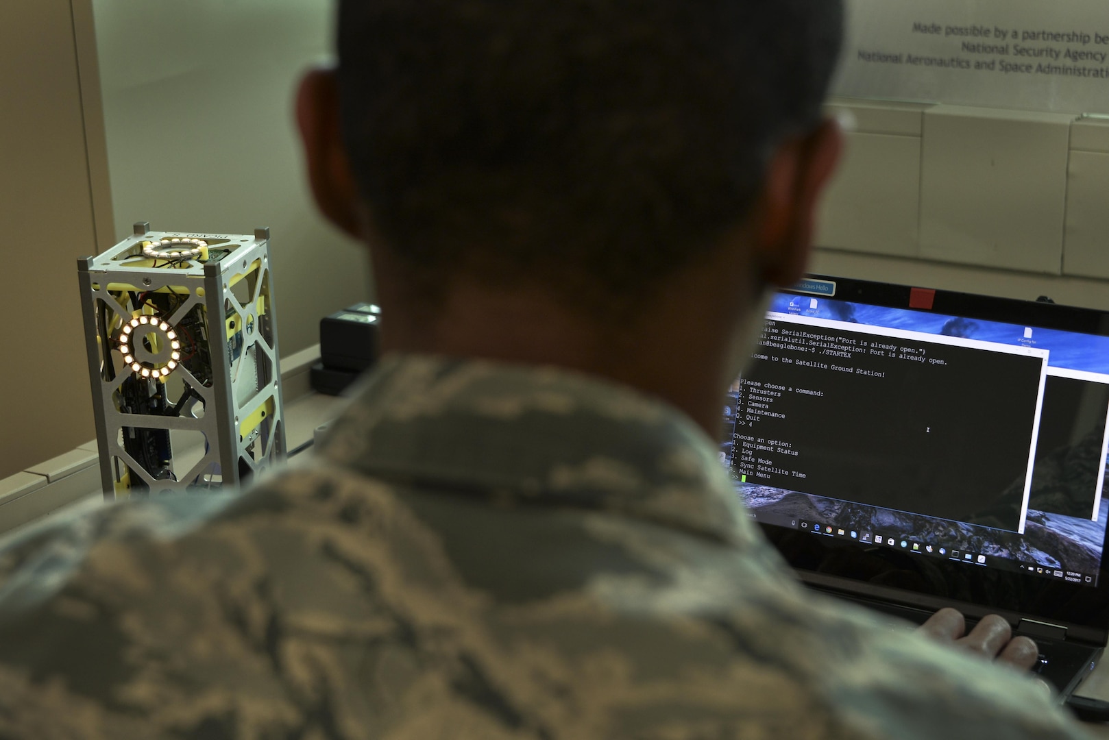 An Airman from the 707th Communications Squadron connects a miniature satellite, or CubeSat, to a ground station through a secure shell connection during the Space Cyber Challenge May 22, 2017, in Linthicum Heights, Maryland. Five 707th CS Airmen, alongside NSA personnel and NASA engineers, competed with graduate students from the Royal Military College of Canada during the event. (U.S. Air Force photo/Staff Sgt. Alexandre Montes)  