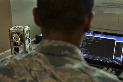An Airman from the 707th Communications Squadron connects a miniature satellite, or CubeSat, to a ground station through a secure shell connection during the Space Cyber Challenge May 22, 2017, in Linthicum Heights, Maryland. Five 707th CS Airmen, alongside NSA personnel and NASA engineers, competed with graduate students from the Royal Military College of Canada during the event. (U.S. Air Force photo/Staff Sgt. Alexandre Montes)  