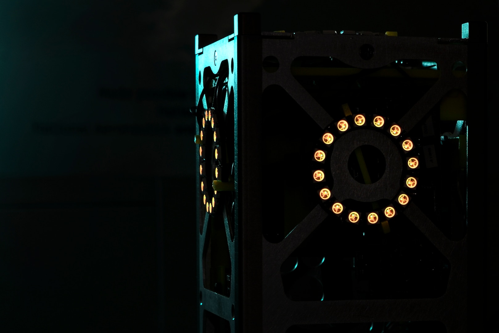 The glowing LED lights on a miniature satellite, or CubeSat, simulate its thrusters firing during a demonstration May 22, 2017, in Linthicum Heights, Maryland. Five 707th CS Airmen, alongside NSA personnel and NASA engineers, competed with graduate students from the Royal Military College of Canada in a Space Cyber Challenge. (U.S. Air Force photo/Staff Sgt. Alexandre Montes) 
