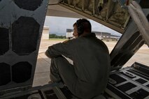 U.S. Air Force Reserve Tech Sgt. Nate Castle, loadmaster, 327th Airlift Squadron, sits on the back of a C-130J Super Hercules as pilots perform an aircraft backing during exercise Prime Horizon June 3, 2017, at Keesler Air Force Base, Miss. During the backing maneuver, loadmasters must give voice directed commands to the pilot since the pilots cannot see where they are going or obstacles they might make contact with. (U.S. Air Force photo by Master Sgt. Jeff Walston/Released)