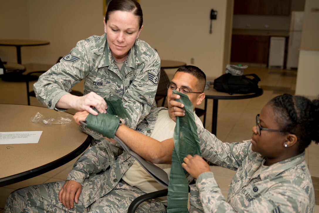 U.S. Air Force Reserve Staff Sgt. Rachel Clark, personnel journeyman, and Senior Airman Alexandria, career development, splint the arm of Tech Sgt. Robert Porras, customer service NCOIC, during exercise Prime Horizon June 3, 2017, at Keesler Air Force Base, Miss.  All three Airmen are assigned 913th Force Support Squadron and were participating in the 913th Airlift Group’s first readiness exercise. (U.S. Air Force photo by Master Sgt. Jeff Walston/Released)