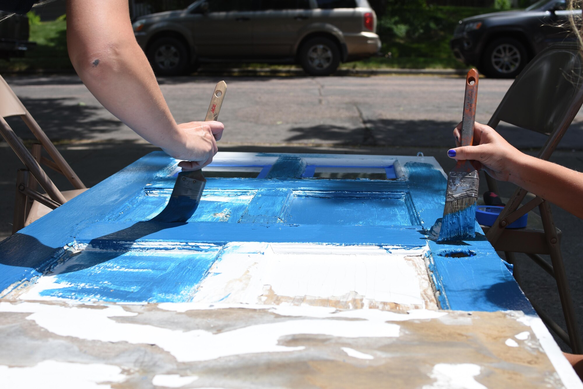 114th Fighter Wing Rising 6 member and a family member paints a door during the Paint the Town event June 10, 2017, in Sioux Falls, S.D. Paint the Town event is an all day event where a houses are nominated by friends, family, and neighbors to be prepped and painted by volunteers. (U.S. Air National Guard photo by Staff Sgt. Duane Duimstra/Released)