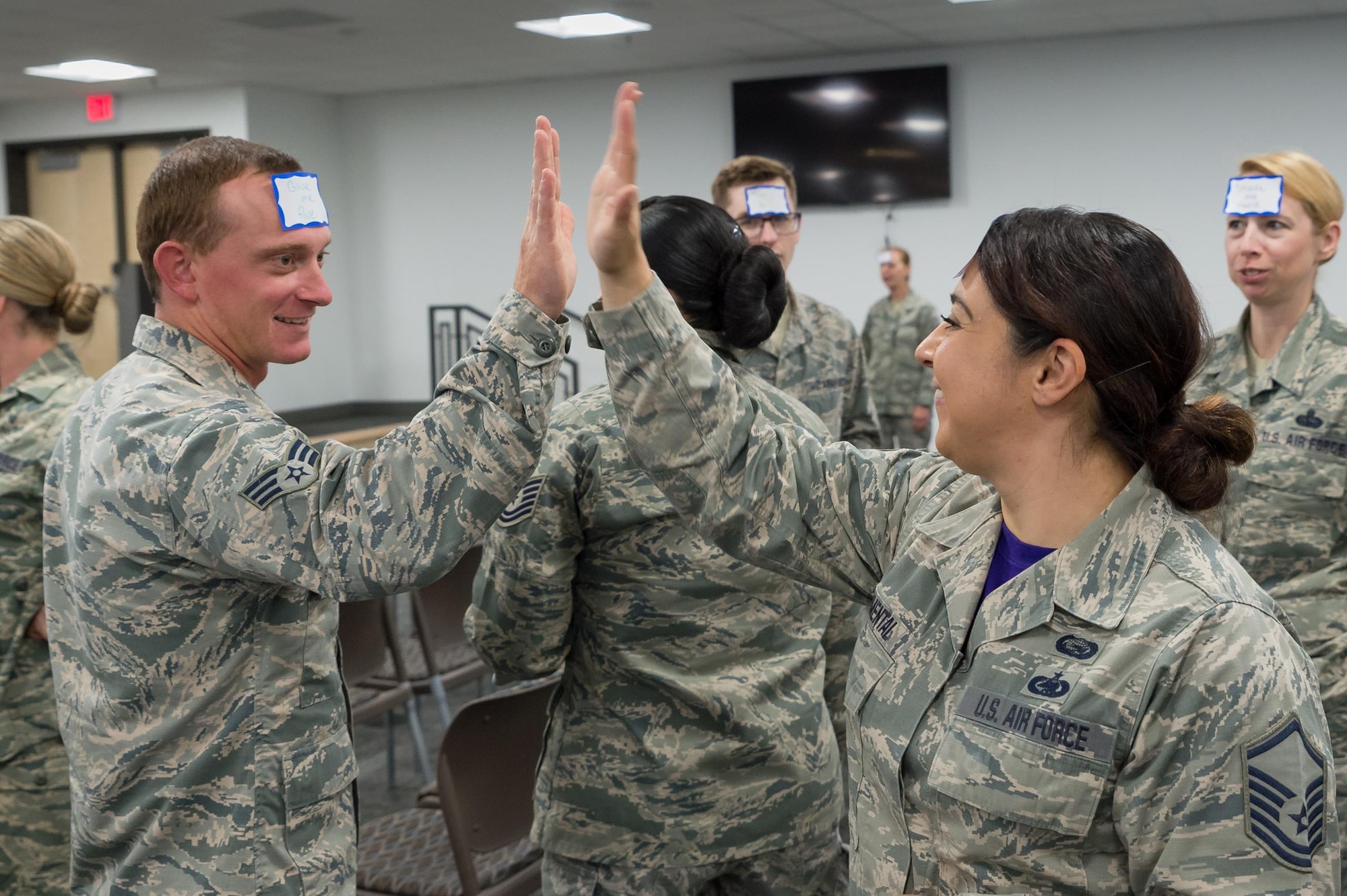 U.S. Air Force Master Sgt. Emma Simental gives a high-five to Senior Airman Spencer Hess during a brown bag lunch presentation, June 10, 2016 in Cheyenne, Wyoming. Simental, Hess and other Airmen with the 153rd Airlift Wing participated in interactive activities and listened to speakers on diversity, inclusion, and the power of mentoring. (U.S. Air National Guard photo by Senior Master Sgt. Charles Delano/released)