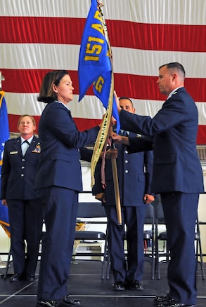 Col. Kristin Streukens, commander of the 151st Air Refueling Wing, hands the 151st Operations Group guidon to Lt. Col. Robert Taylor, commander of the 151st Operations Group, during an assumption of command ceremony held at Roland R. Wright Air National Guard Base on June 11, 2017. (U.S. Air National Guard photo by Tech. Sgt. Annie Edwards)