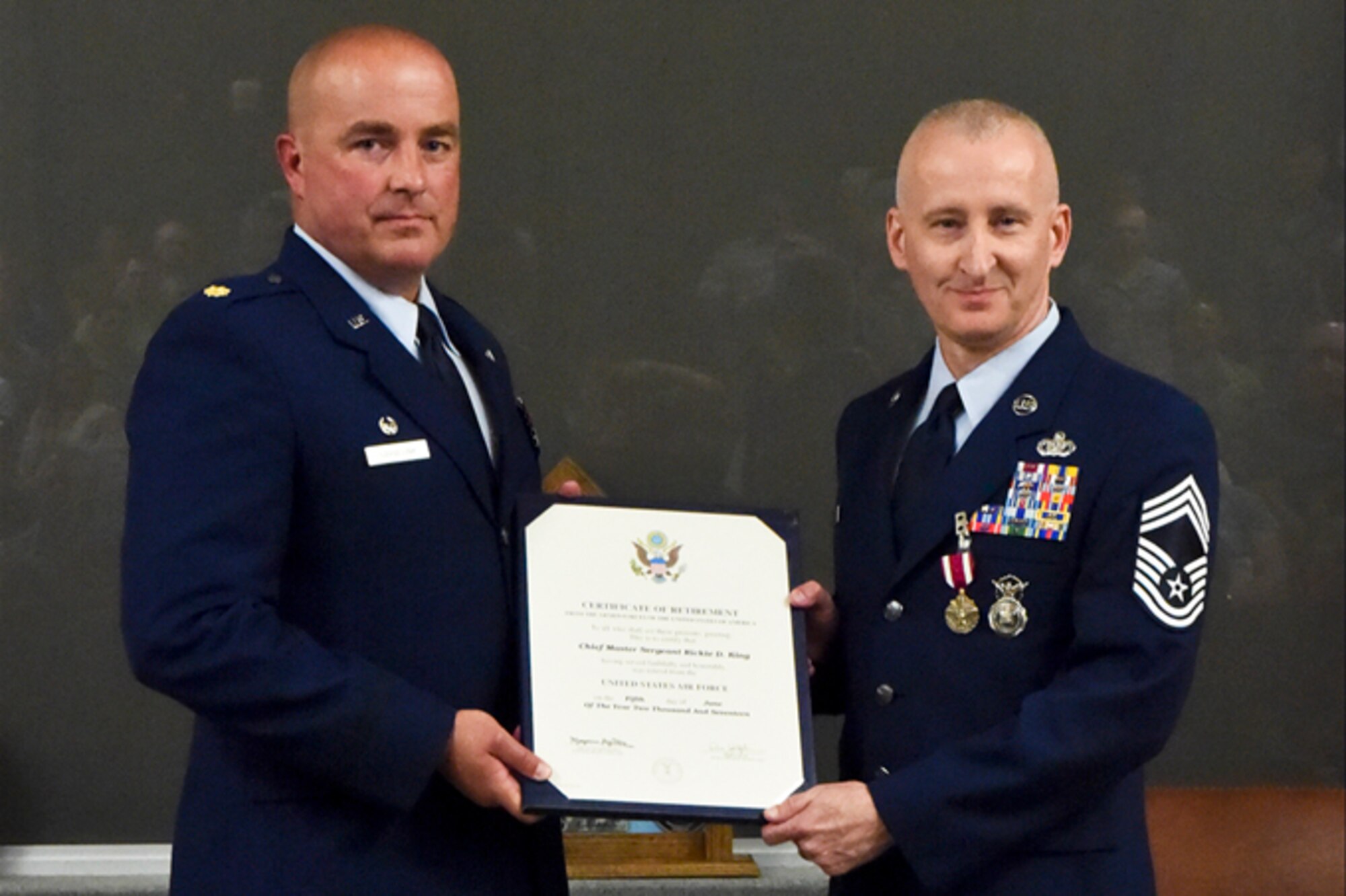Maj. Matthew Garvelink, 434th Security Forces Squadron commander, presents a certificate of retirement to Chief Master Sgt. Rickie King, 434th SFS manager, at a retirement ceremony at Grissom Air Reserve Base, Ind., June 3, 2017. King retired after serving 27 years in the Air Force. (U.S. Air Force photo/ Senior Airman Cali Wetli)