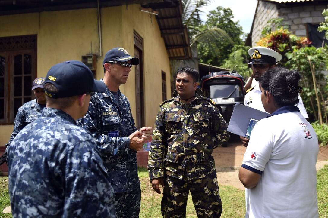 Navy Capt. Darren McPherson, commanding officer of the Ticonderoga-class guided missile cruiser USS Lake Erie, converses with Sri Lanka Red Cross representatives and a Sri Lankan marine concerning pumping water wells to support humanitarian assistance operations in the wake of severe flooding and landslides that devastated many regions of the country in Colombo, Sri Lanke, June 12, 2017. Recent heavy rainfall brought by a southwest monsoon triggered flooding and landslides throughout the country, displacing thousands of people and causing significant damage to homes and buildings. Navy photo by Petty Officer  3rd Class Lucas T. Hans