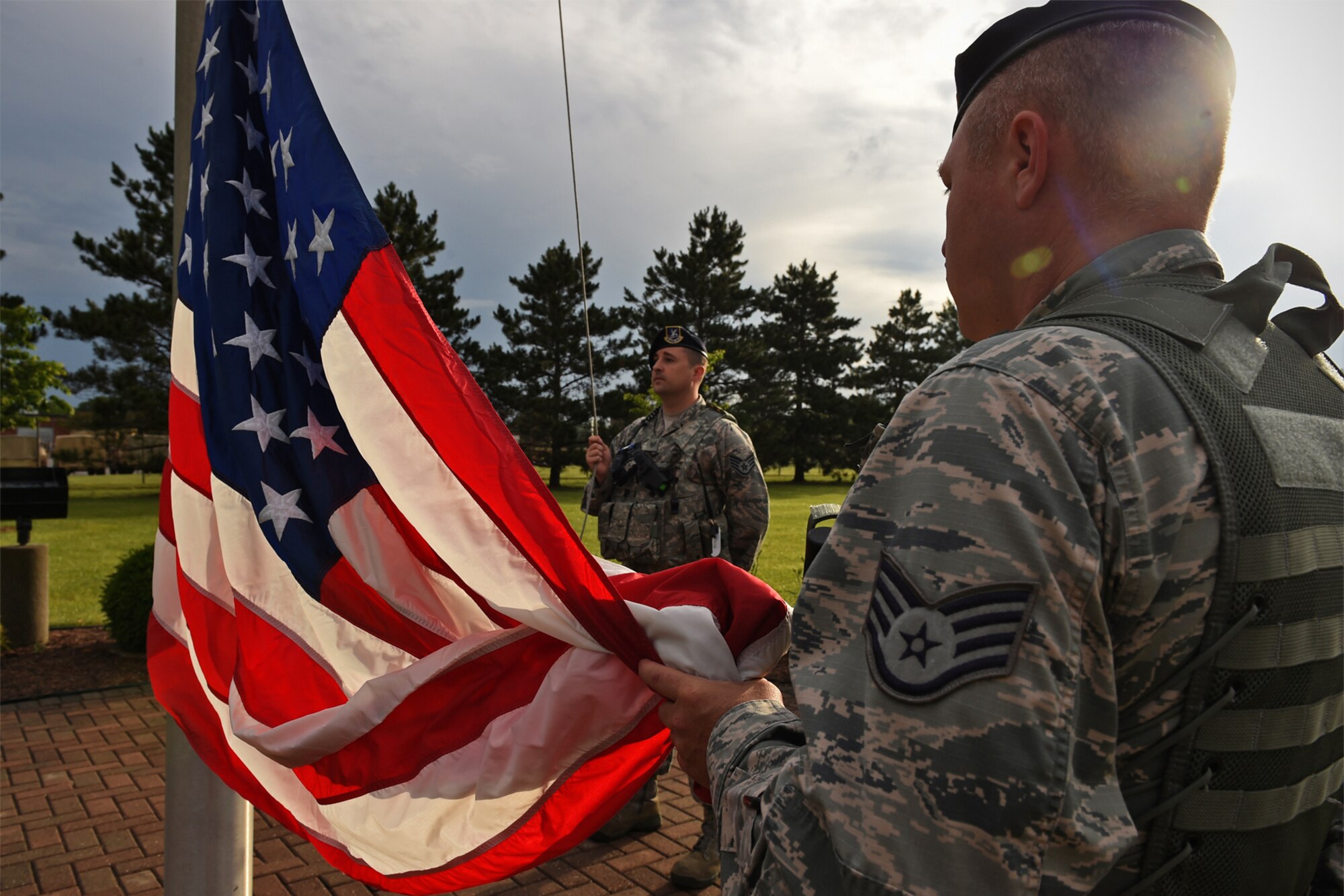 Staff Sgt. Michael Willis, 434th Security Forces Squadron security response team member (right), and Staff Sgt. Timothy Sommers, 434th SFS security response team member, prepare to raise the American flag at the sound of reveille June 14, 2017 at Grissom Air Reserve Base, Ind. Flag Day was officially established as June 14, the anniversary of the 1777 resolution, by President Woodrow Wilson with a proclamation made in 1916. (U.S. Air Force photo/Staff Sgt. Katrina Heikkinen)