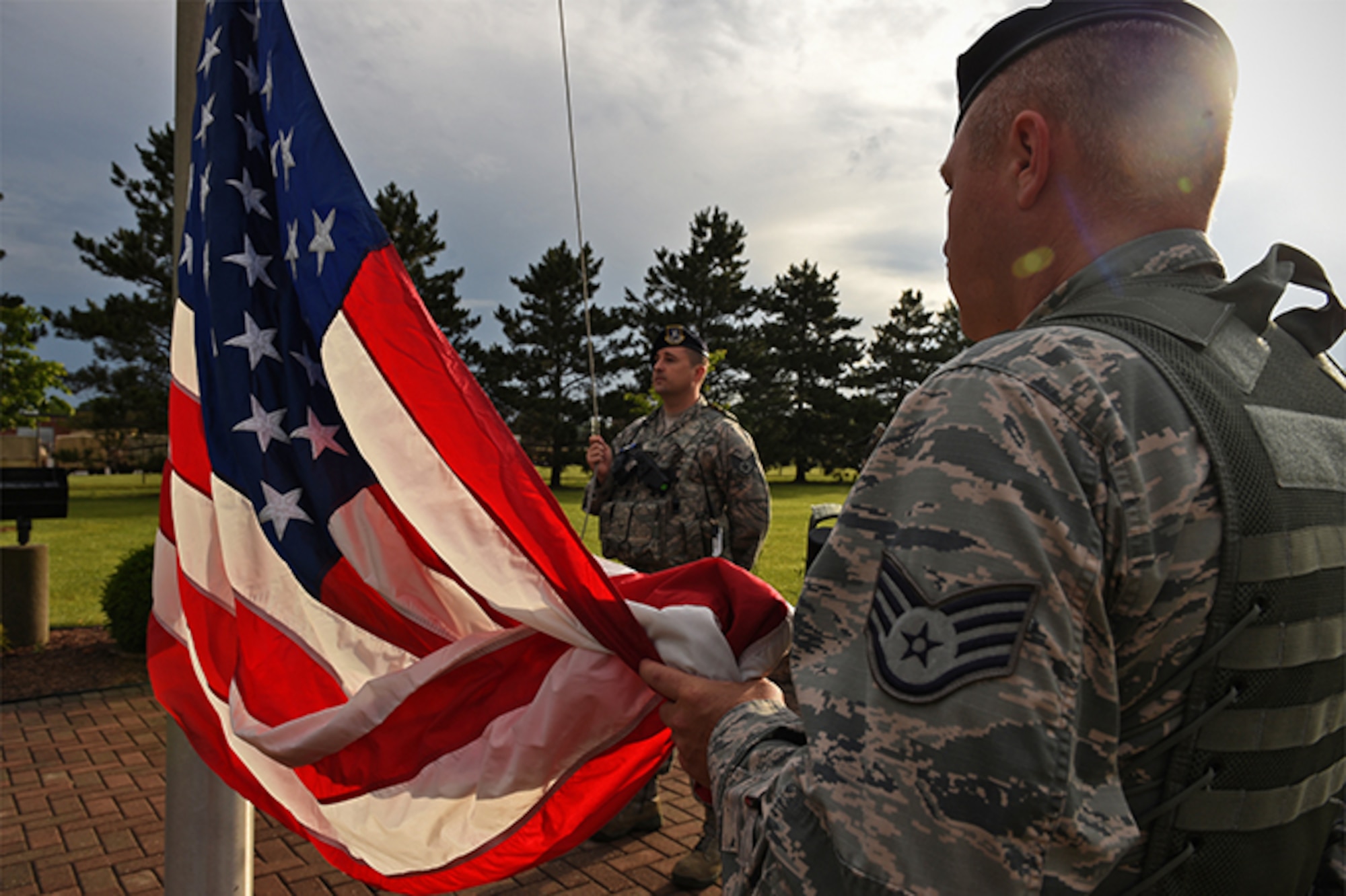 Staff Sgt. Michael Willis, 434th Security Forces Squadron security response team member (right), and Staff Sgt. Timothy Sommers, 434th SFS security response team member, prepare to raise the American flag at the sound of reveille June 14, 2017 at Grissom Air Reserve Base, Ind. Flag Day was officially established as June 14, the anniversary of the 1777 resolution, by President Woodrow Wilson with a proclamation made in 1916. (U.S. Air Force photo/Staff Sgt. Katrina Heikkinen)