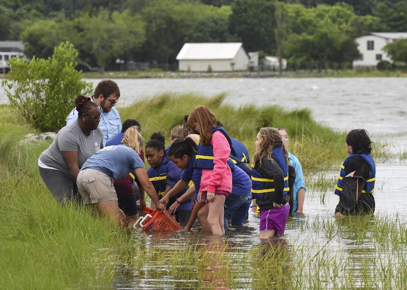 Students from Booker Elementary School and Chesapeake Bay Foundation members lay oyster shells during an oyster planting event at Joint Base Langley-Eustis, Va., June 8, 2017. The new reef, built near the Langley Air Force Base marina, measured approximately 25 feet by one foot, satisfying the young oysters’ need of a hard surface to settle and grow. (U.S. Air Force photo/Airman 1st Class Anthony Nin Leclerec)