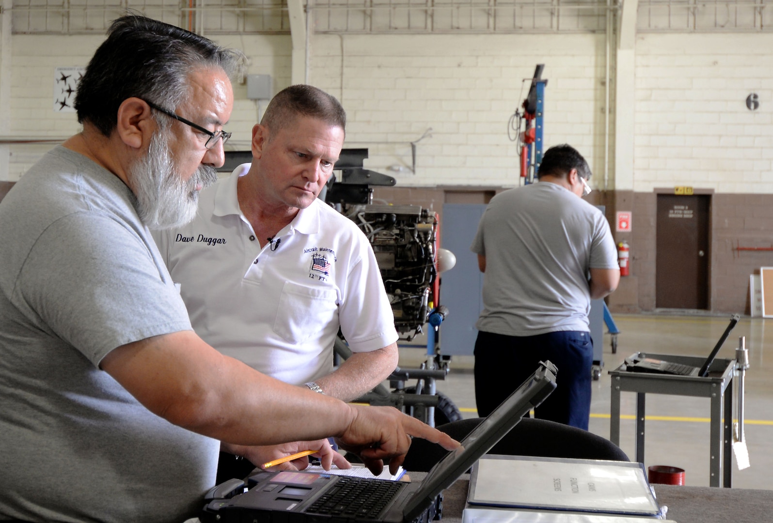 Dave Duggar, propulsion shop supervisor, receives an update on one of the J-85 engines from one of his team members inside Hangar 5 at Joint Base San Antonio-Randolph, Texas, May 8, 2017.