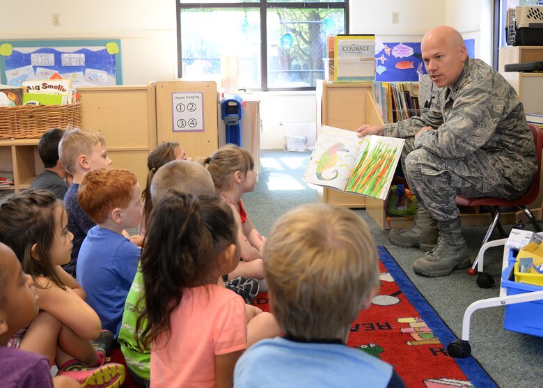 Col. Roman L. Hund (left), installation commander, reads “Mister Seahorse” by Eric Carle to children at the Child Development Center June 12. Hund was invited to read to children by CDC officials. (U.S. Air Force photo by Linda LaBonte Britt)