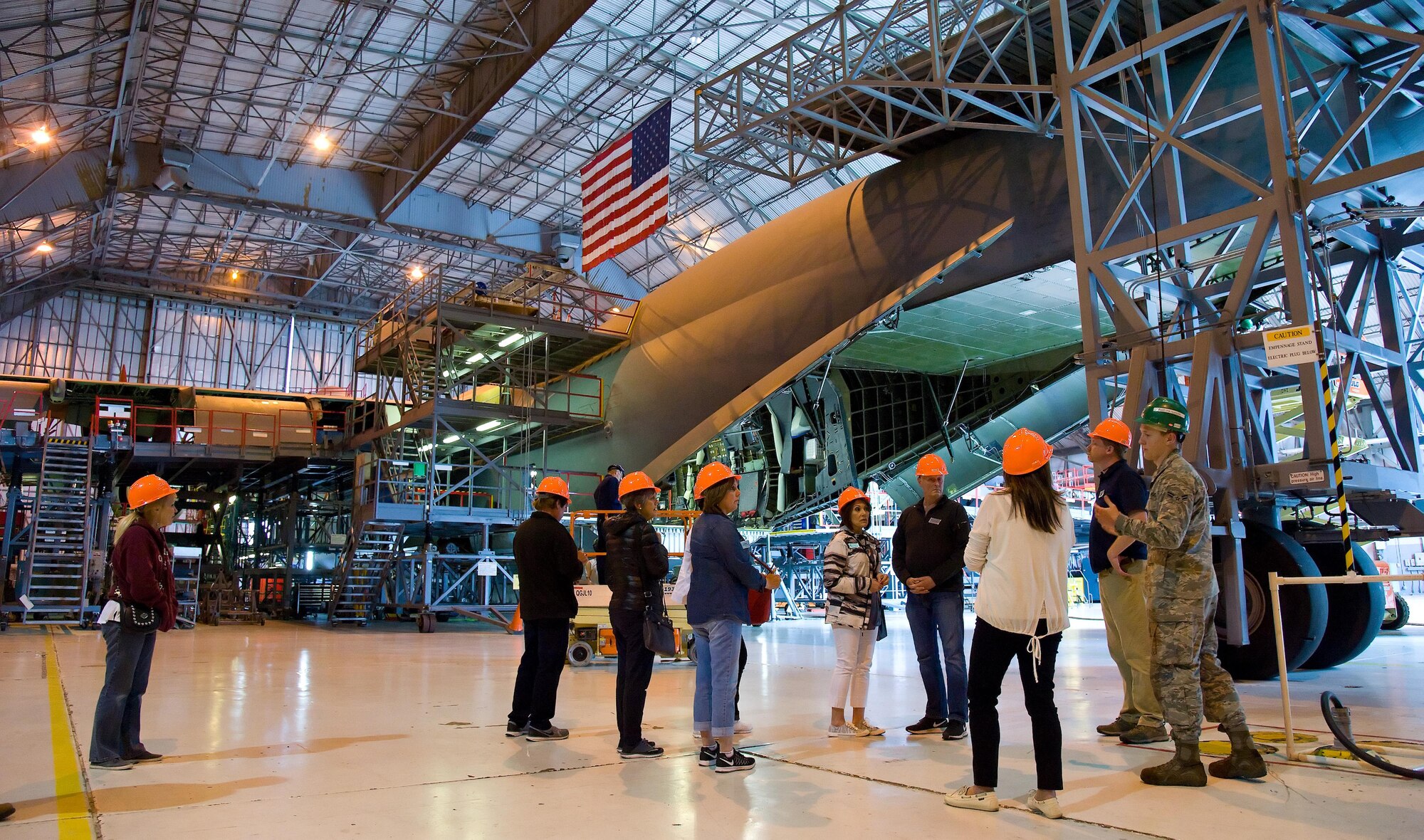 Airman 1st Class Jacob Dulcie, 436th Maintenance Squadron crew chief, leads honorary commanders and civic leaders from Joint Base Lewis-McChord, Wash., around the tail section of a C-5M Super Galaxy undergoing inspection and maintenance June 7, 2017 at the Isochronal Inspection Dock on Dover Air Force Base, Del. The group climbed up the tail stand about six stories to get a birds-eye view of the aircraft in the ISO dock. (U.S. Air Force photo by Roland Balik)