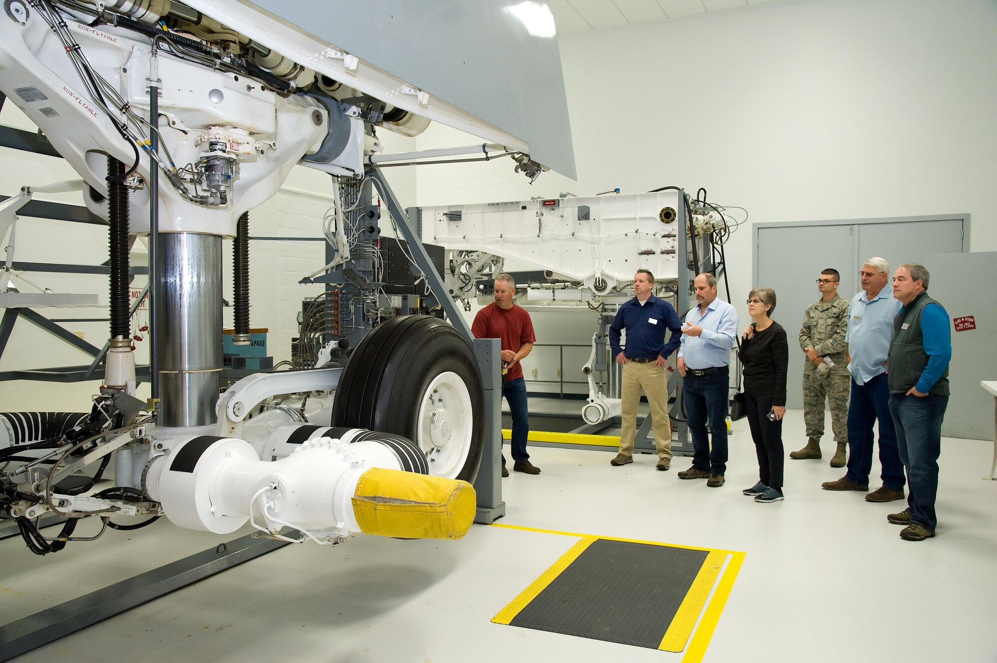 Sam Stiles, 436th Maintenance Group contractor office representative, demonstrates the movements of a C-5 main landing gear maintenance trainer for Joint Base Lewis-McChord, Wash., honorary commanders and civic leaders June 9, 2017 at the 373rd Training Squadron, Detachment 3 on Dover Air Force Base, Del. (U.S. Air Force photo by Roland Balik)