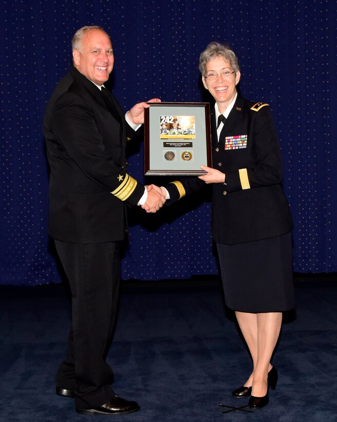 DTRA Deputy Director Rear Adm. Scott Jerabek presents JIDO Vice Director Army Maj. Gen. Julie Bentz an expression of appreciation for her presentation commemorating the Army birthday.