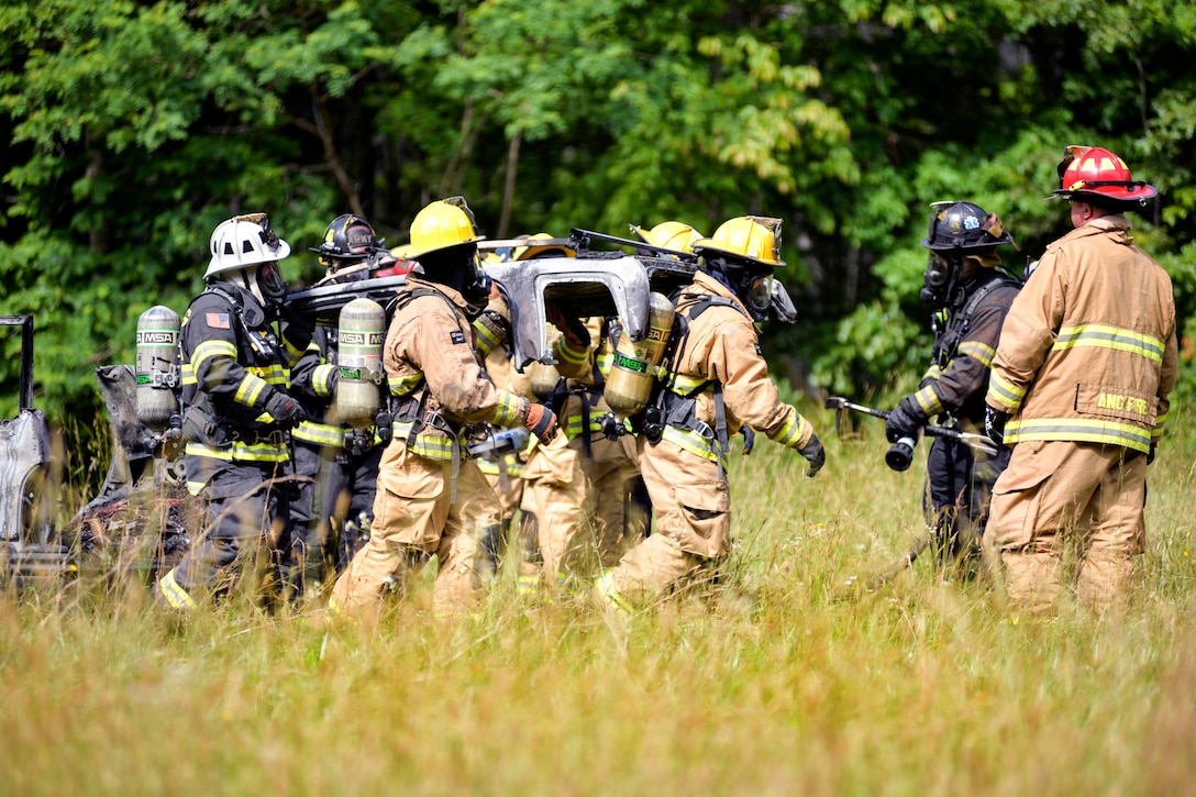 North Carolina Army and Air National Guardsmen move the top portion of a burnt vehicle after searching through simulated wreckage during exercise Operation Vigilant Catamount in Dupont State Forest, Hendersonville, N.C., June 8, 2017. Army National Guard photo by Staff Sgt. David McLean