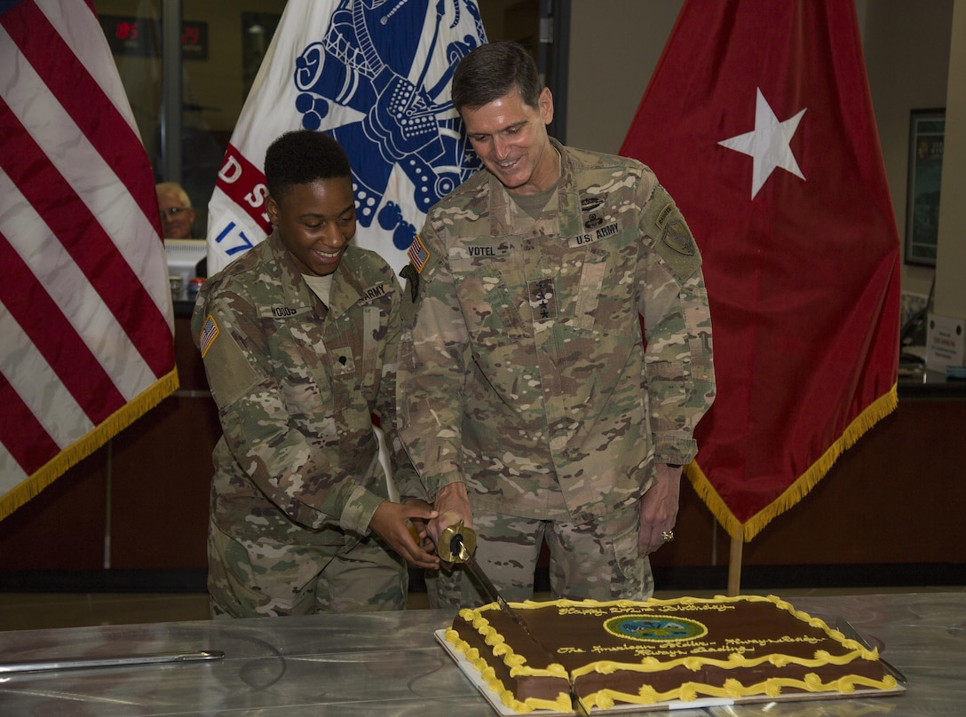 U.S. Army Gen Joseph Votel, commander U.S. Central Command, and Army Specialist Chelsey Woods, representing the oldest and youngest soldier, cut into a cake with a ceremonial sword. USCENTCOM HQ's Army element celebrated the U.S. Army's 242nd birthday with a cake cutting ceremony. (Photo by Tom Gagnier)