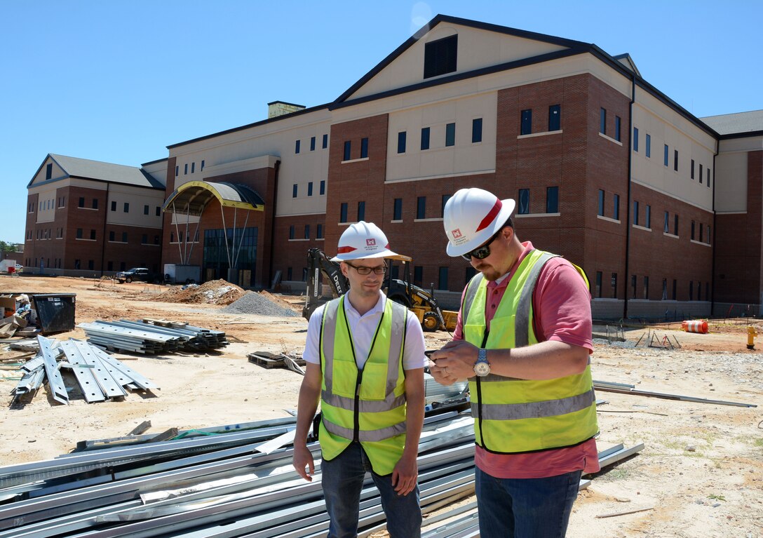 Project Engineers Joshua Kallam, left, and Anthony Byrd of the Wilmington District’s Special Operations Command Area Office check data from the construction of the Language and Cultural Center. See article below at right.  (USACE photo by Hank Heusinkveld)
