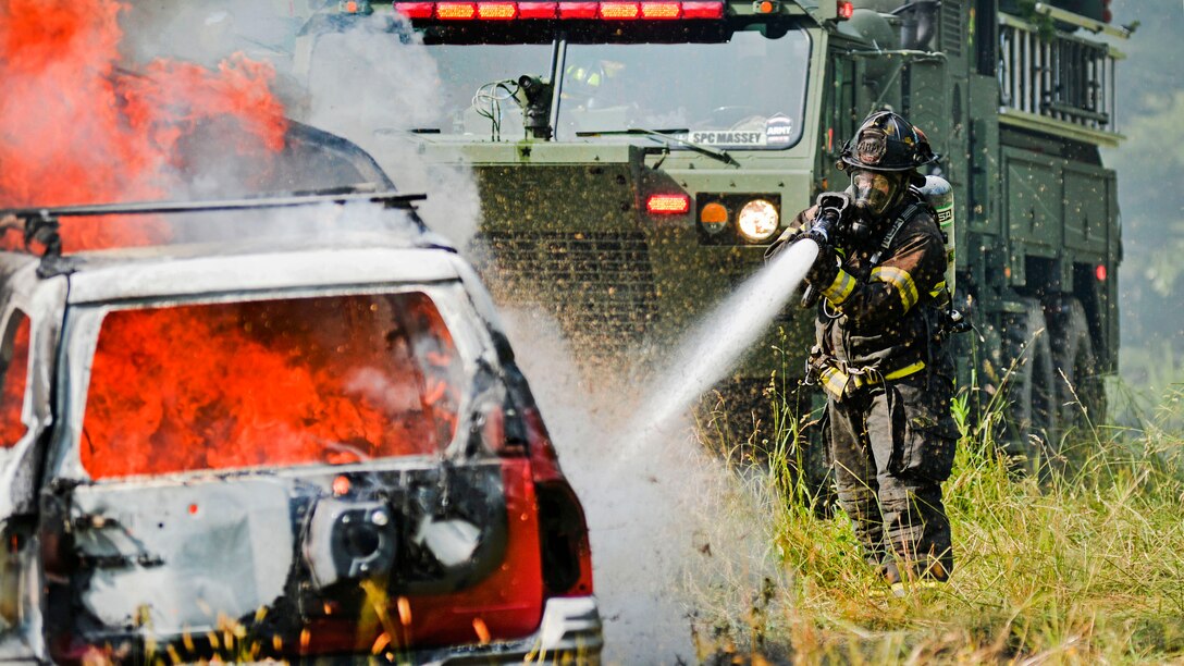 A North Carolina National Guard firefighter puts out a fire at a simulated crash site in DuPont State Forest, N.C., June 8, 2017, during Operation Vigilant Catamount. The operation is a joint civilian and North Carolina National Guard homeland security exercise. North Carolina National Guard soldiers and airmen participated in the exercise. Army National Guard photo by Staff Sgt. David McLean