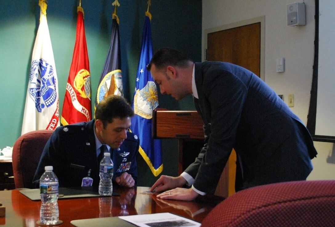 Department of Defense Cyber Crime Center Damaged Media Recovery Specialist Scott Lalliss briefs B-1B bomber pilot Lt. Col. Frank A. Biancardi II April 27, 2017, at Linthicum, Md. They discussed Lalliss's findings from the data recorder recovered from the August 2013 plane crash Biancardi was involved in. (DC3 photo/Kelvin Johnson)     
