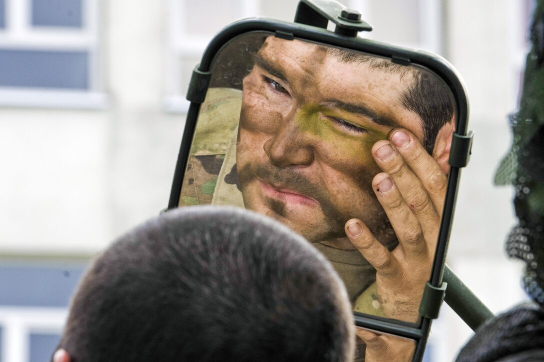 A soldier uses the mirror on his Stryker vehicle to paint his face before a multinational field training exercise as part of Saber Strike 17 in Bemowo Piskie, Poland, June 13, 2017. Saber Strike is an annual U.S. Army Europe-led exercise aimed at enhancing the NATO alliance throughout the Baltic region and Poland. Army photo by Sgt. Justin Geiger
