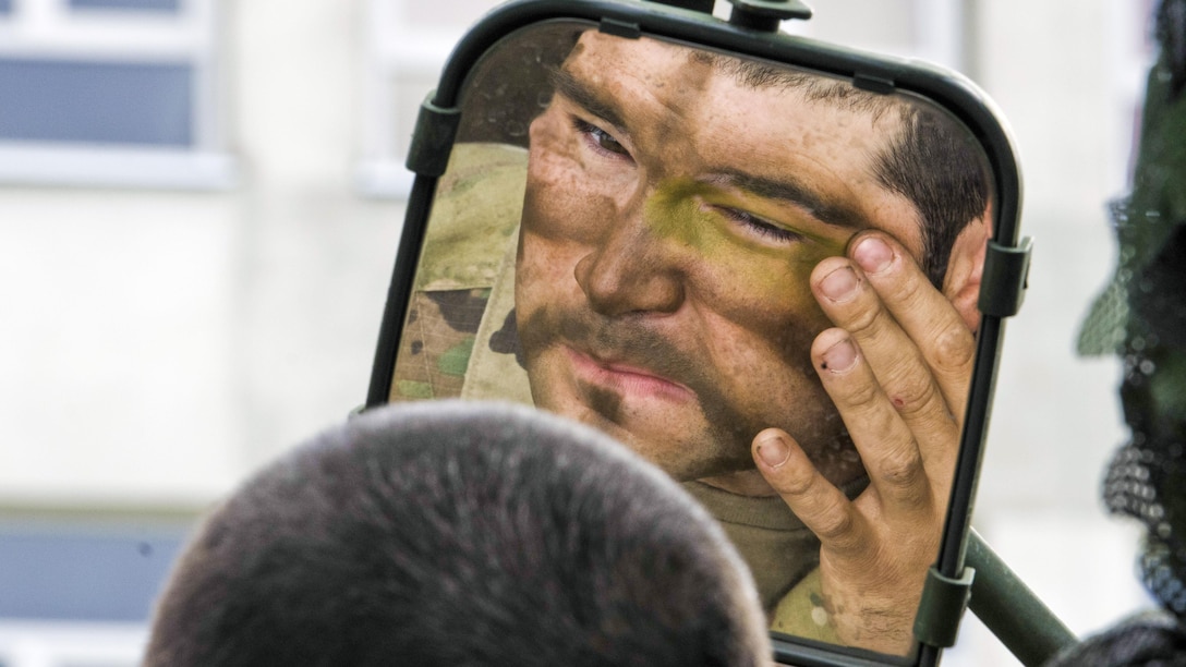 A soldier uses the mirror on his Stryker vehicle to paint his face before a multinational field training exercise as part of Saber Strike 17 in Bemowo Piskie, Poland, June 13, 2017. Saber Strike is an annual U.S. Army Europe-led exercise aimed at enhancing the NATO alliance throughout the Baltic region and Poland. Army photo by Sgt. Justin Geiger