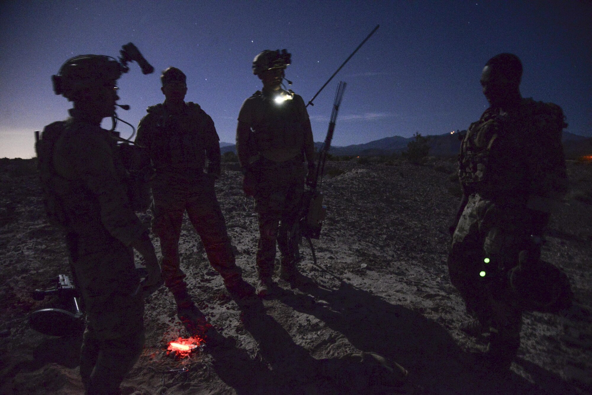 99th Civil Engineer Squadron explosive ordnance team members discuss how to safely disable a simulated roadside bomb at night during a bivouac exercise at the Nevada Test and Training Range, June 7, 2017. The training proctors based the scenarios off of real-world experiences they faced in deployed environments. (U.S. Air Force photo by Airman 1st Class Andrew D. Sarver/Released)