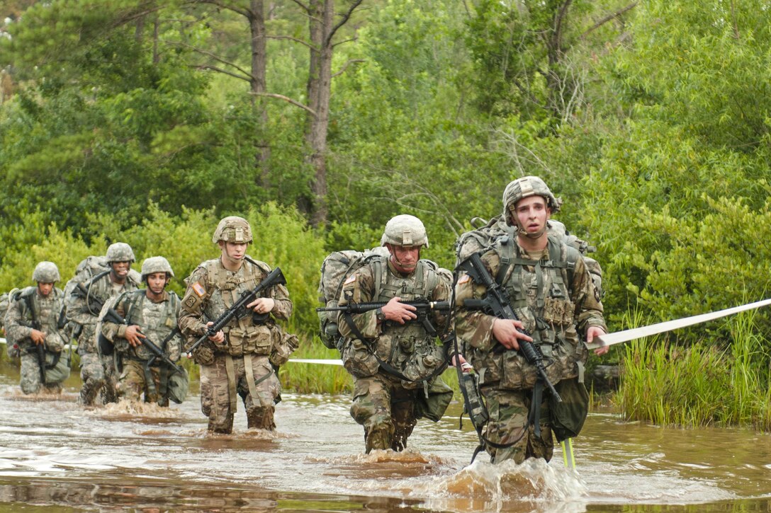 Soldiers cross a water obstacle at the end of an early morning 10-kilometer ruck march during the 2017 Army Reserve Best Warrior Competition at Fort Bragg, N.C., June 13, 2017. The competition determines the top noncommissioned officer and junior enlisted soldier who will represent the Army Reserve in the Department of the Army Best Warrior Competition later in the year. Army photo by Sgt. David Turner
