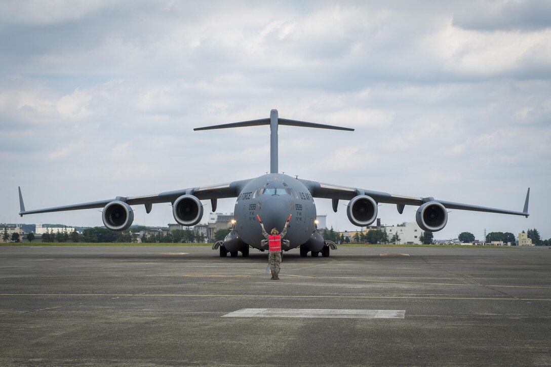 A C-17 Globe Master is marshaled to a parking spot, June 6, 2017, at Yokota Air Base, Japan. The C-17 is part of the Noncombatant Evacuation Operations exercise, Focused Passage 2017, designed to exercise NEO procedures for an evacuation of U.S. citizens from the Republic of Korea. (U.S. Air Force photo by Airman 1st Class Donald Hudson)