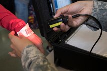 U.S. Army Specialist Brianna Doo, U.S. Army in Japan band, scans a bracelet with a Noncombatant Evacuation Operations tracking system (NTS) barcode at Yokota Air Base, Japan, during noncombatant evacuation exercise Focused Passage 2017. Eighth Army conducts NEO administrative and training tasks designed to inspect NEO packets, conduct NEO representative/warden training, NTS operator training, and account for all Department of Defense noncombatants. (U.S. Air Force photo by Yasuo Osakabe)