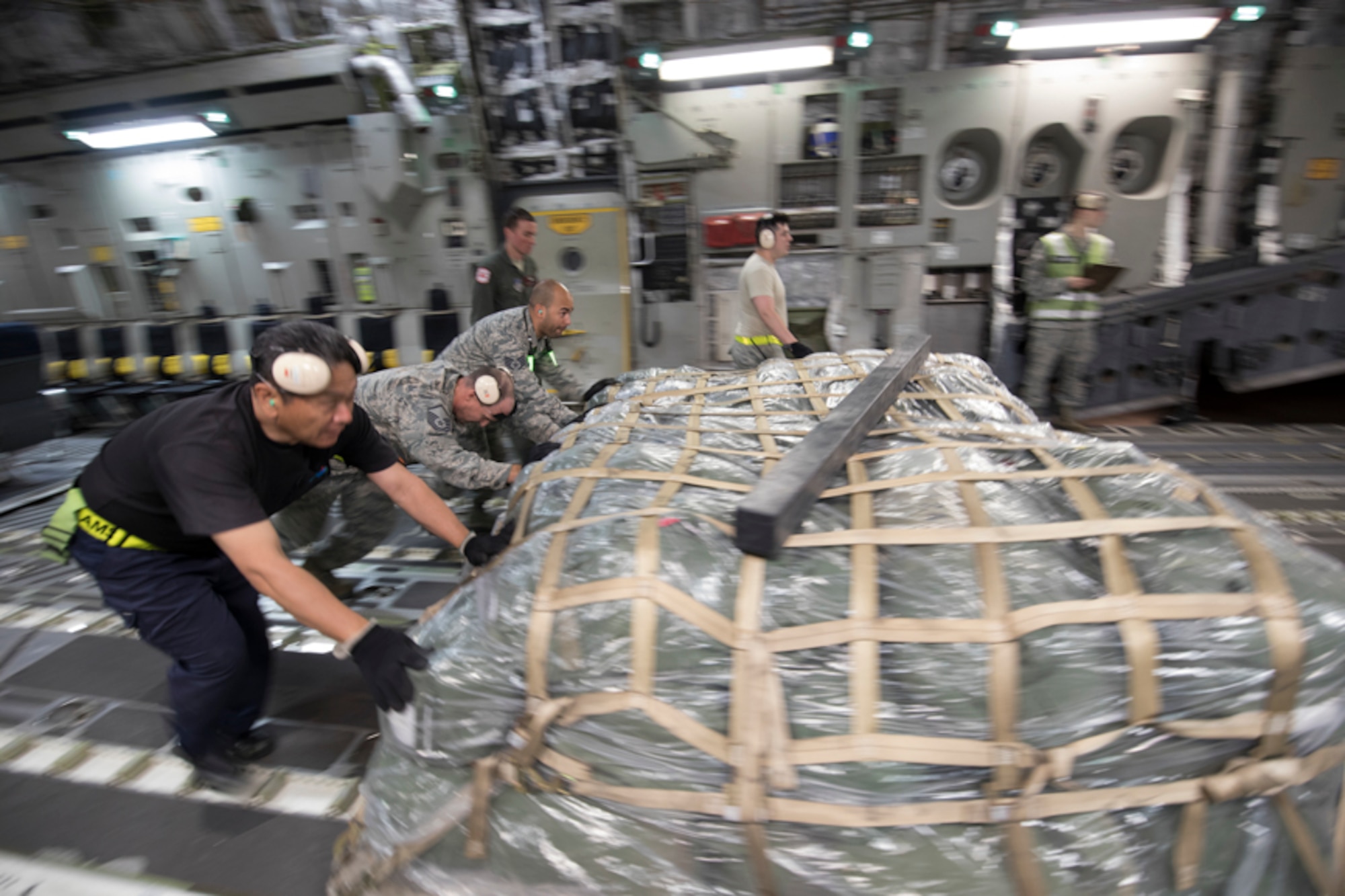 Members with the 730th Air Mobility Squadron unload a bundle from a C-17 Globemaster III at Yokota Air Base, Japan, June 6, 2017, during exercise Focused Passage 2017. FP 2017 is designed to exercise the command’s Noncombatant Evacuation Operations procedures for an evacuation from the Republic of Korea. (U.S. Air Force photo by Yasuo Osakabe)