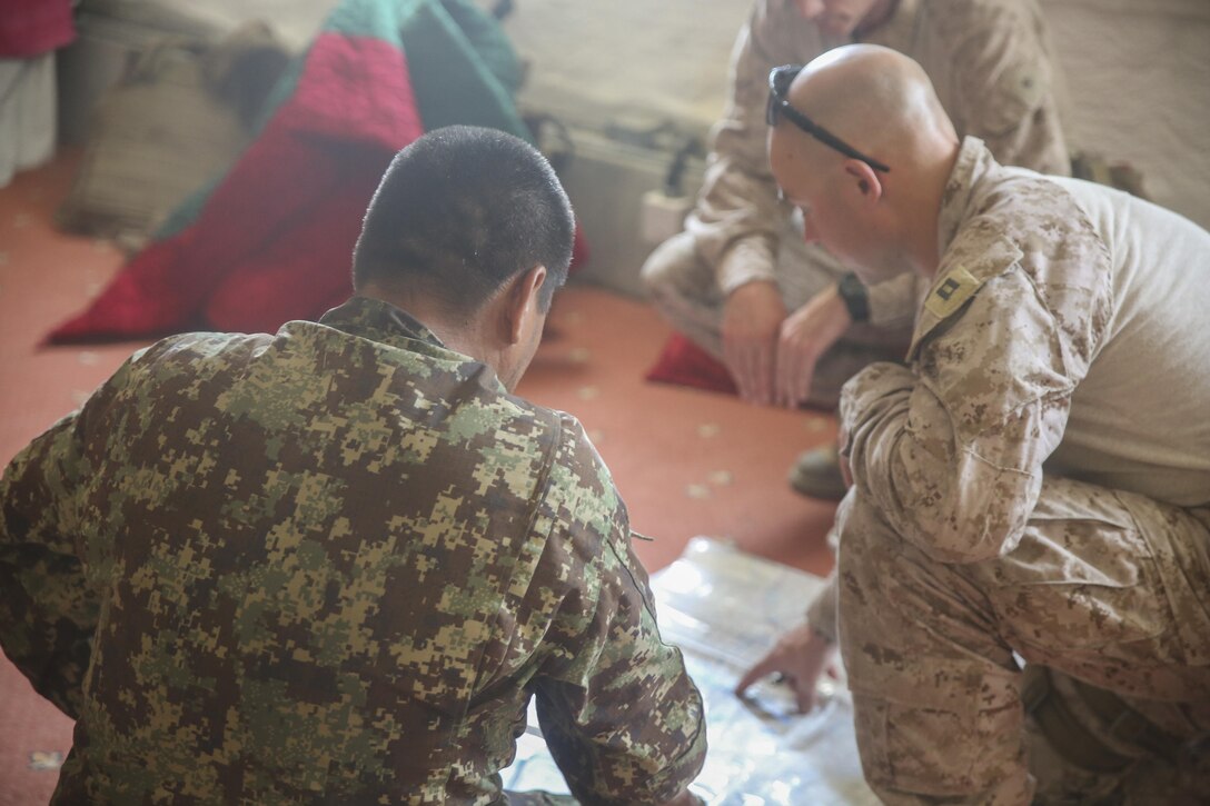 An Afghan National Army soldier with the 215th Corps and a U.S. Marine advisor with Task Force Southwest discuss offensive strategy during an advisory meeting at Camp Hanson, Afghanistan, June 13, 2017. Marines and Sailors from Task Force Southwest are supporting and assisting the 1st and 3rd Brigades of the 215th Corps during Operation Maiwand Three, which is designed to clear Nad-e Ali and Marjah of insurgents. (U.S. Marine Corps photo by Sgt. Lucas Hopkins)