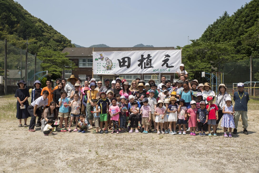 Marine Corps Air Station Iwakuni residents and local Japanese volunteers pose for a photo after participating in a Cultural Adaptation Program rice-planting event in Iwakuni City, Japan, June 10, 2017. The event is held annually in June, after the rice seeds that were sown during April and May are grown and ready to be planted. Giving station residents the opportunity to participate in events like these is part of the Cultural Adaptation Program’s ongoing mission to show Americans Japanese customs and traditions. (U.S. Marine Corps photo by Lance Cpl. Carlos Jimenez)