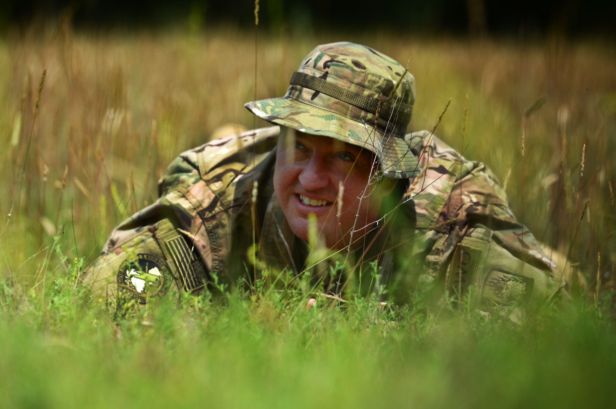 U.S. Air Force Tech. Sgt. James Binari, 7th Weather Squadron Detachment 4 NCO in charge of mission integration function, performs a concealment exercise at the Mainz Sand Dunes, Germany, June 13, 2017. While administratively part of the Air Force, Army weather support Airmen are embedded with the U.S. Army and certify in a number of Soldier tasks. (U.S. Air Force photo by Airman 1st Class Joshua Magbanua))