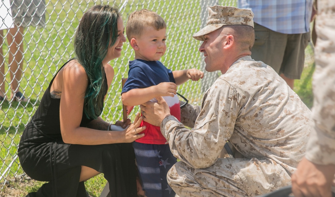 Sgt. Christopher Toy, squad leader, 4th Platoon, Company C., Fleet Anti-terrorism Security Team, U.S. Marine Corps Security Force Regiment, is greeted by his wife and son upon his return  to Camp Allen, Norfolk, Va., June 12, after a six-month deployment to Bahrain. During the deployment, Marines from 4th platoon reinforced embassies in Kuwait and Oman, participated in Operation Eager Lion in Jordan, and set up defensive plans for Bahrain Marine Corps and Bahrain National Guard, to list a few. (U.S. Marine Corps photo by Sgt. Kayla D. Rivera/Released)