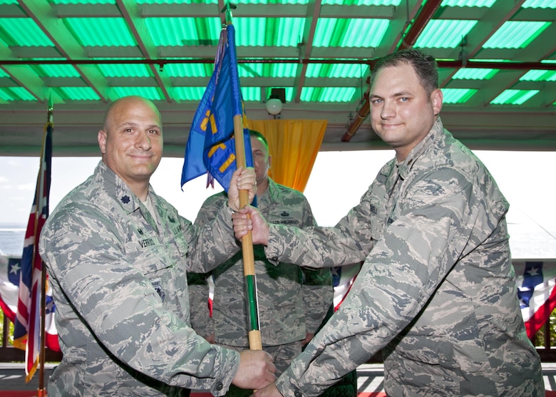 Lt. Col. Phillip Verroco, 21st Space Operations Squadron commander, presents the unit guidon to Maj. Derrick Russell during the 21 SOPS, Detachment 1 change of command ceremony at Diego Garcia, British Indian Ocean Territory, Wednesday, June 6, 2017. Russell assumed command of the detachment from Maj. Tyler Westerberg. (Courtesy photo)
