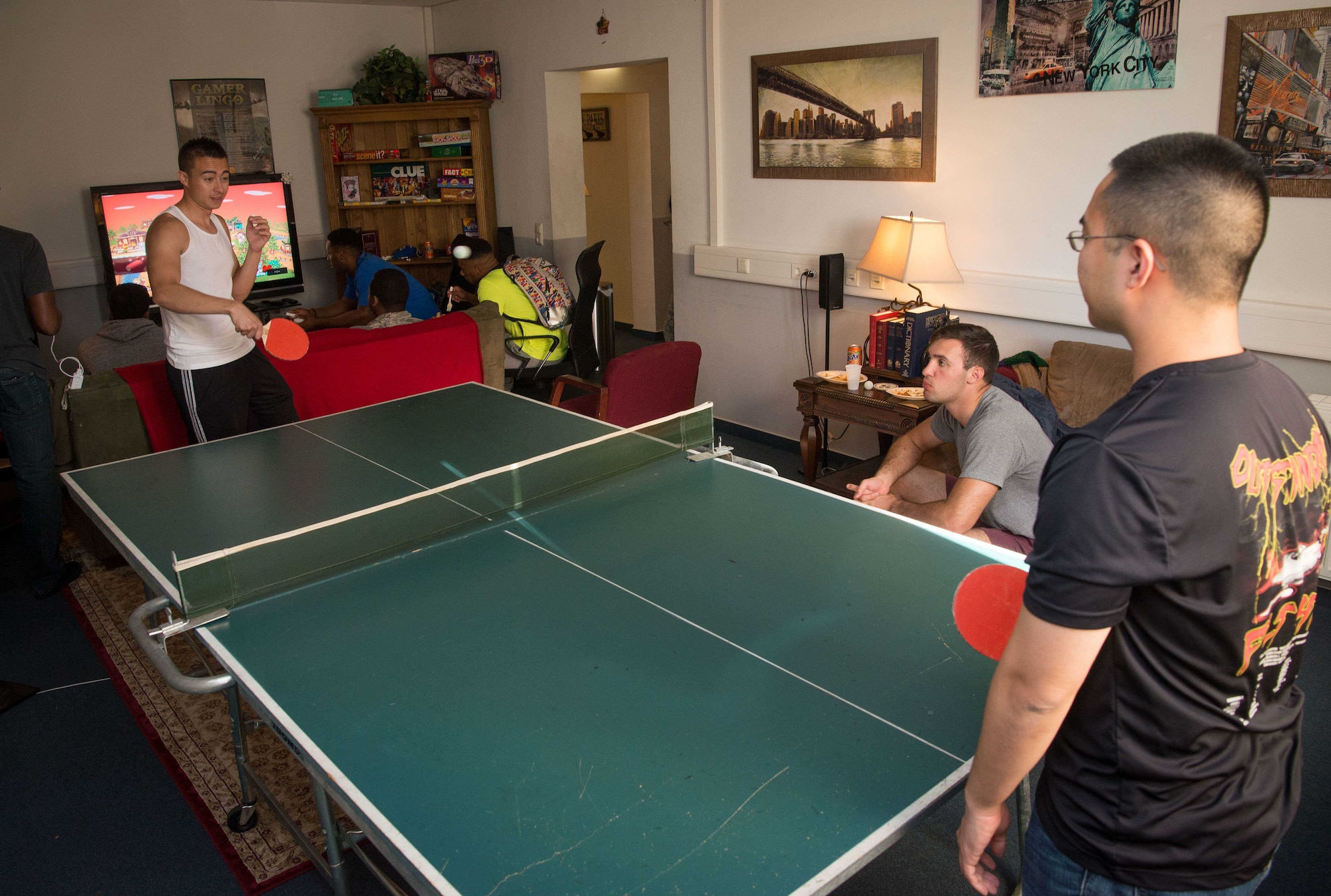 Airmen play ping pong in the game room at Club 7 on Ramstein Air Base, June 10, 2017. The 86th Airlift Wing Chapel’s Airmen Ministry Center runs Club 7 locations on Ramstein and Kapaun Air Station with the goal of providing junior enlisted Airmen a safe “home away from home” atmosphere where they can relax and make friends. (U.S. Air Force photo by Senior Airman Elizabeth Baker)