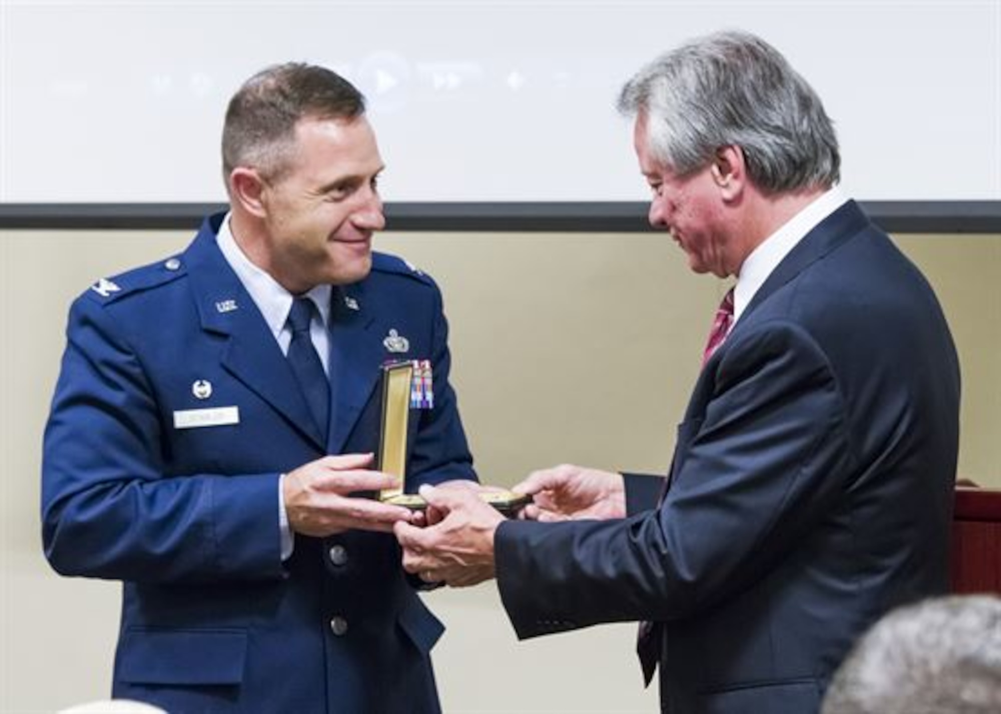 Col. Kirk B. Stabler, the Air Force Office of Special Investigations commander, presents fallen Special Agent Lee Hitchcock’s Bronze Star Medal  to his brother, Craig Hitchcock, during the OSI headquarters inaugural Celebration of Life Remembrance Ceremony May 22, 2017, at Quantico, Va. (U.S. Air Force photo/Michael Hastings)