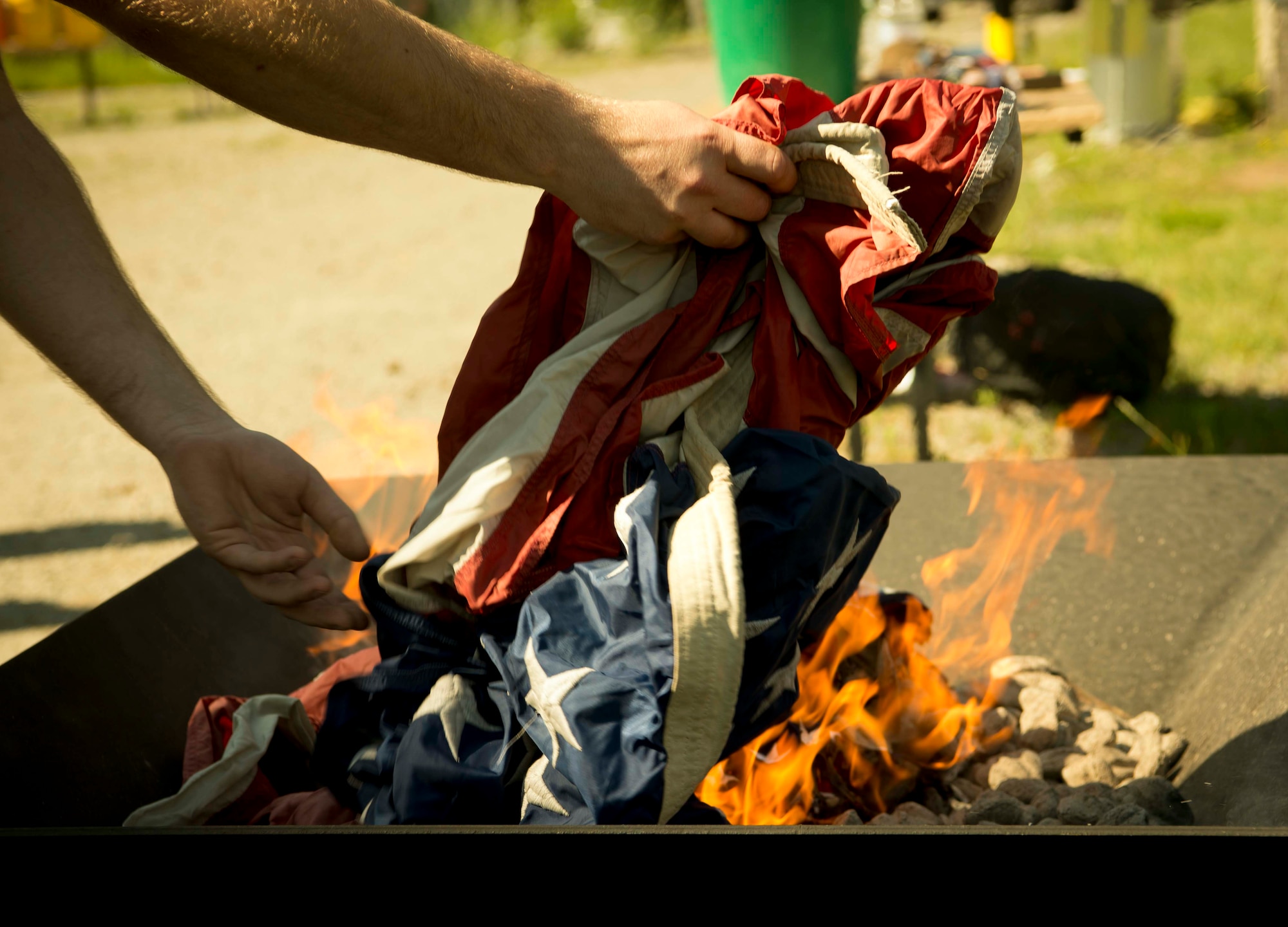 A Cub Scouts of America leader respectfully disposes of a U.S. flag during a Flag Day flag disposal ceremony on Ramstein Air Base, Germany, June 14, 2017. The ceremony was conducted in accordance with the United States Flag Code which states: "The Flag, when it is in such condition that it is no longer a fitting emblem of display, should be destroyed in a dignified way, preferably by burning." (U.S. Air Force photo by Senior Airman Elizabeth Baker.)
